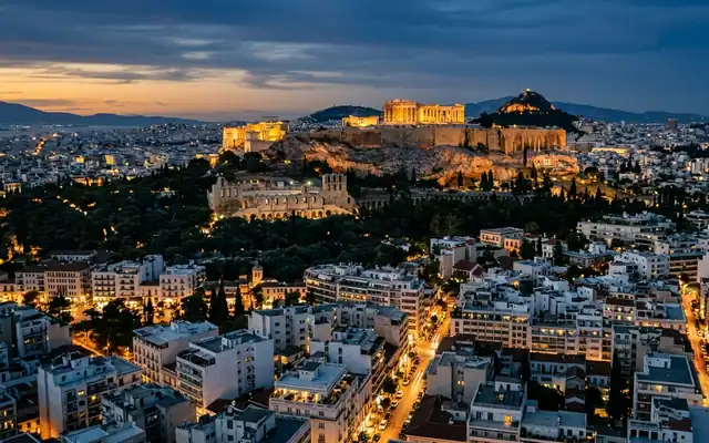 The illuminated Acropolis and Parthenon above the white sprawl of Athens at dusk