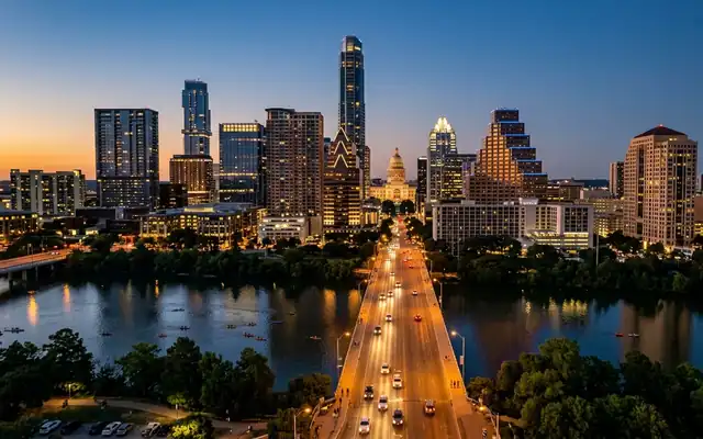The Congress Avenue Bridge leading to the Texas State Capitol amid the Austin skyline at dusk