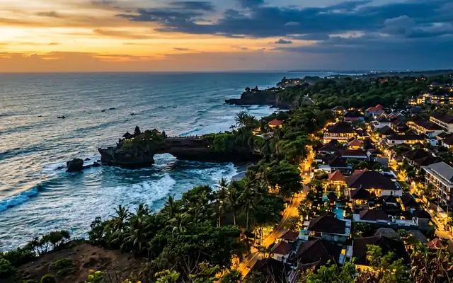 The Tanah Lot sea temple on its rocky outcrop along Bali's coastline at dusk