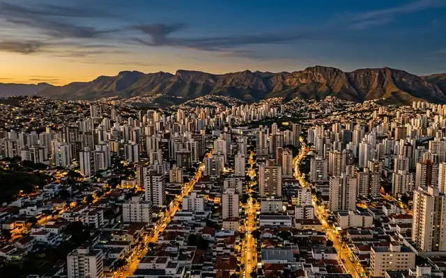 Belo Horizonte at dusk, dense high-rise blocks filling the valley below the long Serra do Curral ridge