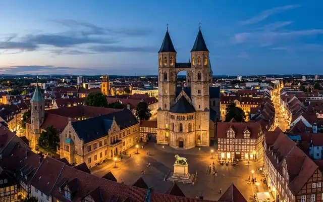 Braunschweig Burgplatz at dusk, the Romanesque cathedral with its two towers joined by a bridge storey and the bronze lion