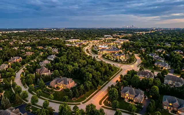 Burr Ridge at dusk, large wooded estates along winding tree-lined streets with the distant Chicago skyline on the horizon