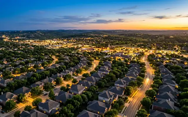 Cedar Park at dusk, leafy suburban rooftops and oak lined streets with the Texas Hill Country ridges behind