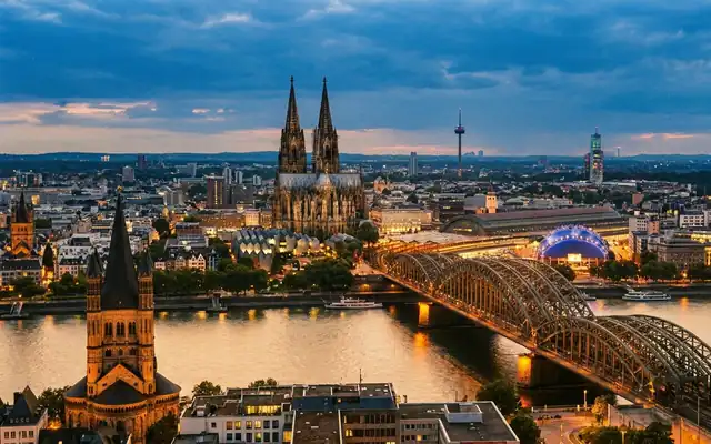 Cologne Cathedral and the Hohenzollern Bridge over the Rhine at dusk