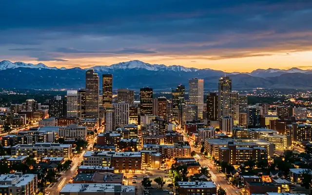The downtown Denver skyline with snow-capped Rocky Mountains on the horizon at dusk