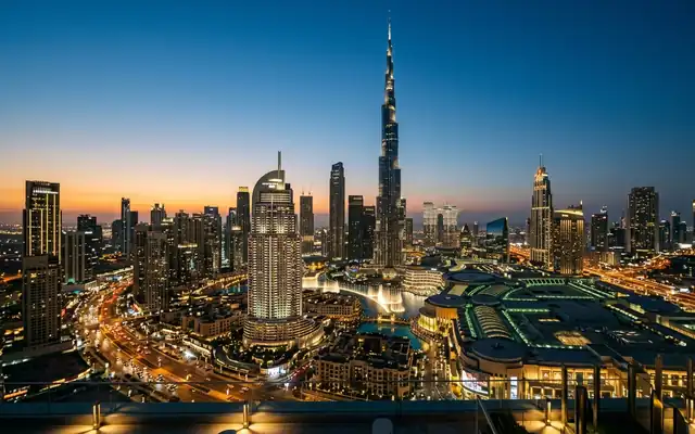 The Burj Khalifa towering over the illuminated Downtown Dubai skyline at dusk