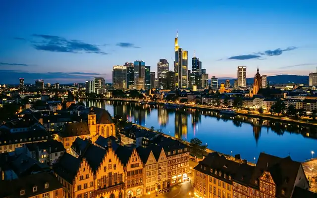 Frankfurt skyline at dusk across the Main river, with the gabled old town in the foreground