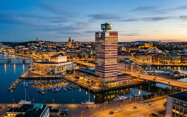 Gothenburg waterfront at dusk, the red and white striped Lappstiftet tower with its glass lookout beside the opera house and marina