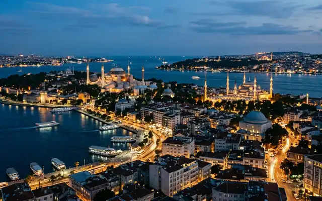 Domes and minarets of Istanbul's illuminated mosques above the Bosphorus at dusk