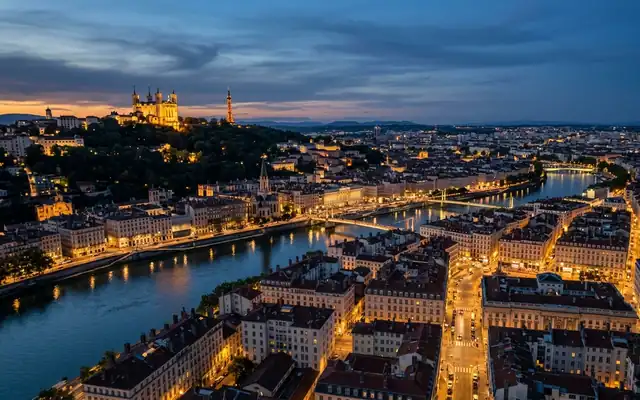 The hilltop Basilica of Notre-Dame de Fourviere above Lyon's rooftops and rivers at dusk