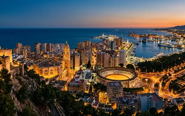 Malaga Cathedral, the La Malagueta bullring and the port from Gibralfaro hill at dusk