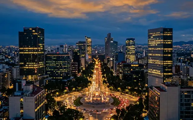 The Angel of Independence on Paseo de la Reforma amid Mexico City high-rises at dusk