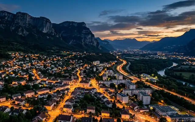 Meylan at dusk, the town below the steep Saint-Eynard cliffs with the Grenoble valley and its motorway beyond