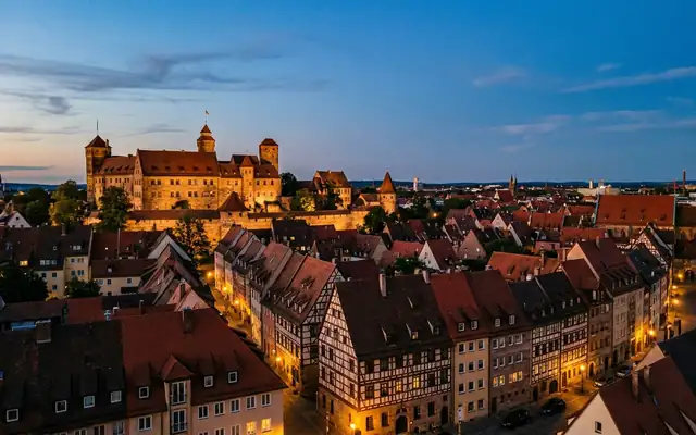 Nuremberg at dusk, the Kaiserburg castle above the red rooftops of the medieval old town