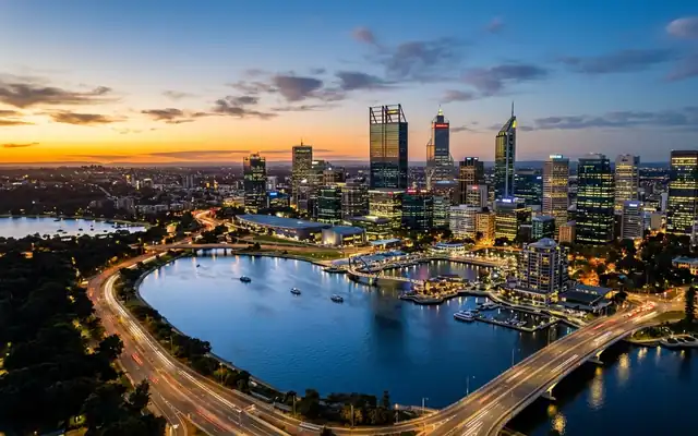The Perth CBD skyline across a wide bend of the Swan River at dusk