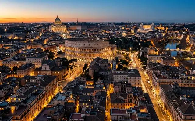 Rome at dusk, the Colosseum amid terracotta rooftops with the dome of St Peter's on the far skyline