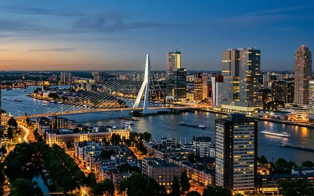 The Erasmus Bridge spanning the Nieuwe Maas against Rotterdam's high-rise skyline at dusk