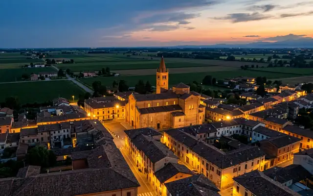 Sala Bolognese at dusk, the brick Romanesque pieve church and its bell tower among flat Po Valley farmland