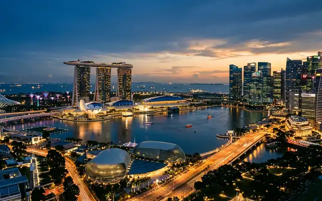 Marina Bay Sands and the Singapore skyline curving around Marina Bay at dusk