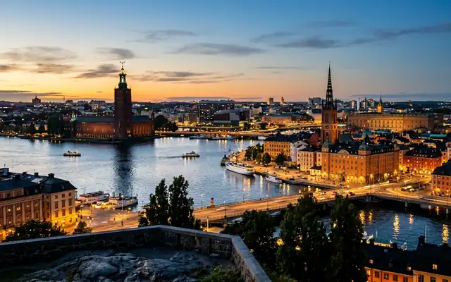 Stockholm City Hall tower and old town church spires across glittering waterways at dusk