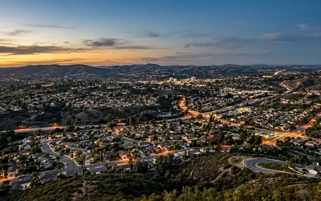 Vista at dusk, suburban homes and palm trees spread over the rolling inland hills of North County San Diego
