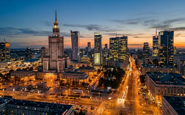 The Palace of Culture and Science spire among modern skyscrapers in Warsaw at dusk