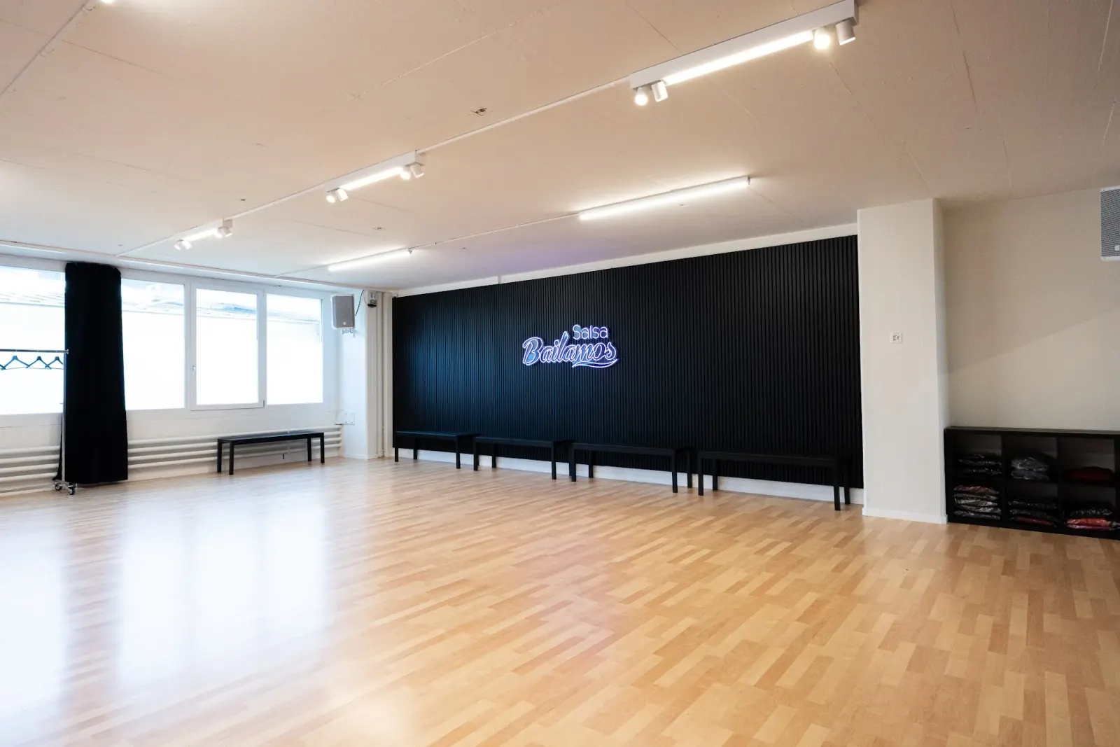 Empty dance studio with neon sign at Bailamos Salsa, Basel