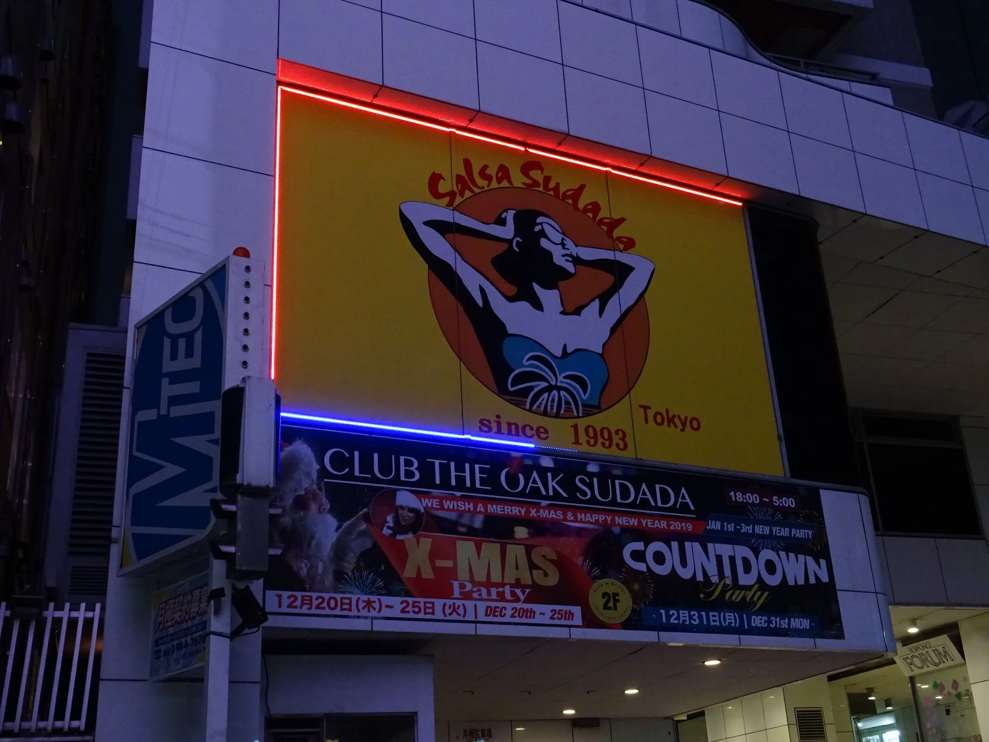 Illuminated venue sign at Salsa Sudada Tokyo at night