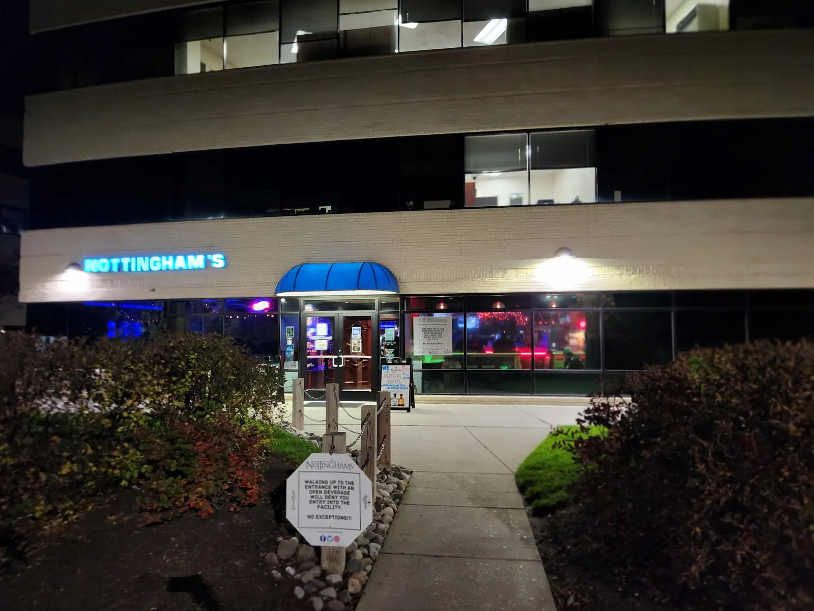 The lit sign and entrance of Nottingham’s Tavern at night in Columbia