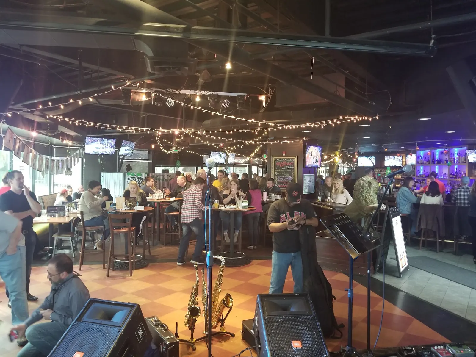 Crowd, string lights and band gear on the checkered floor inside Nottingham’s Tavern in Columbia