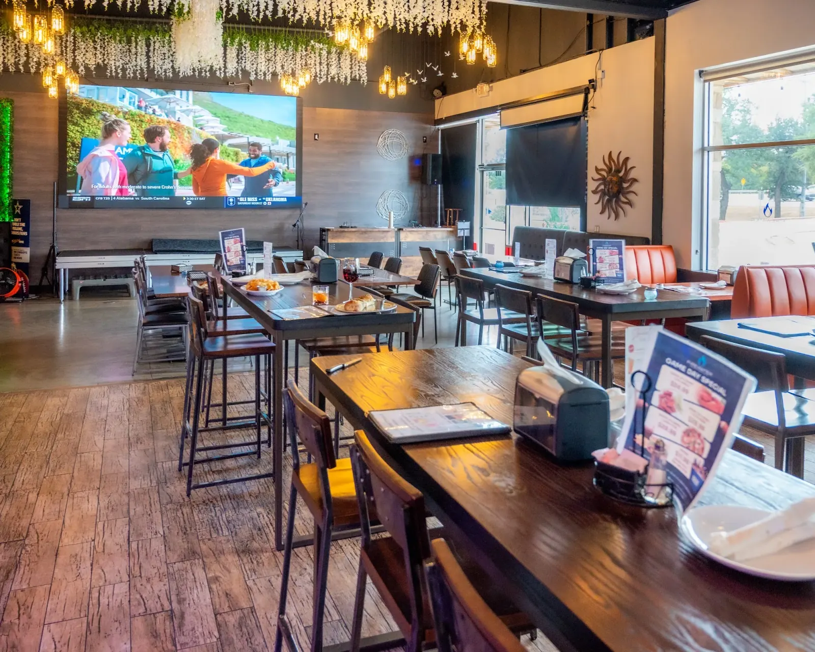 Bar interior with high-top tables and big-screen TVs at Firewater Sports Bar Cafe in Cedar Park