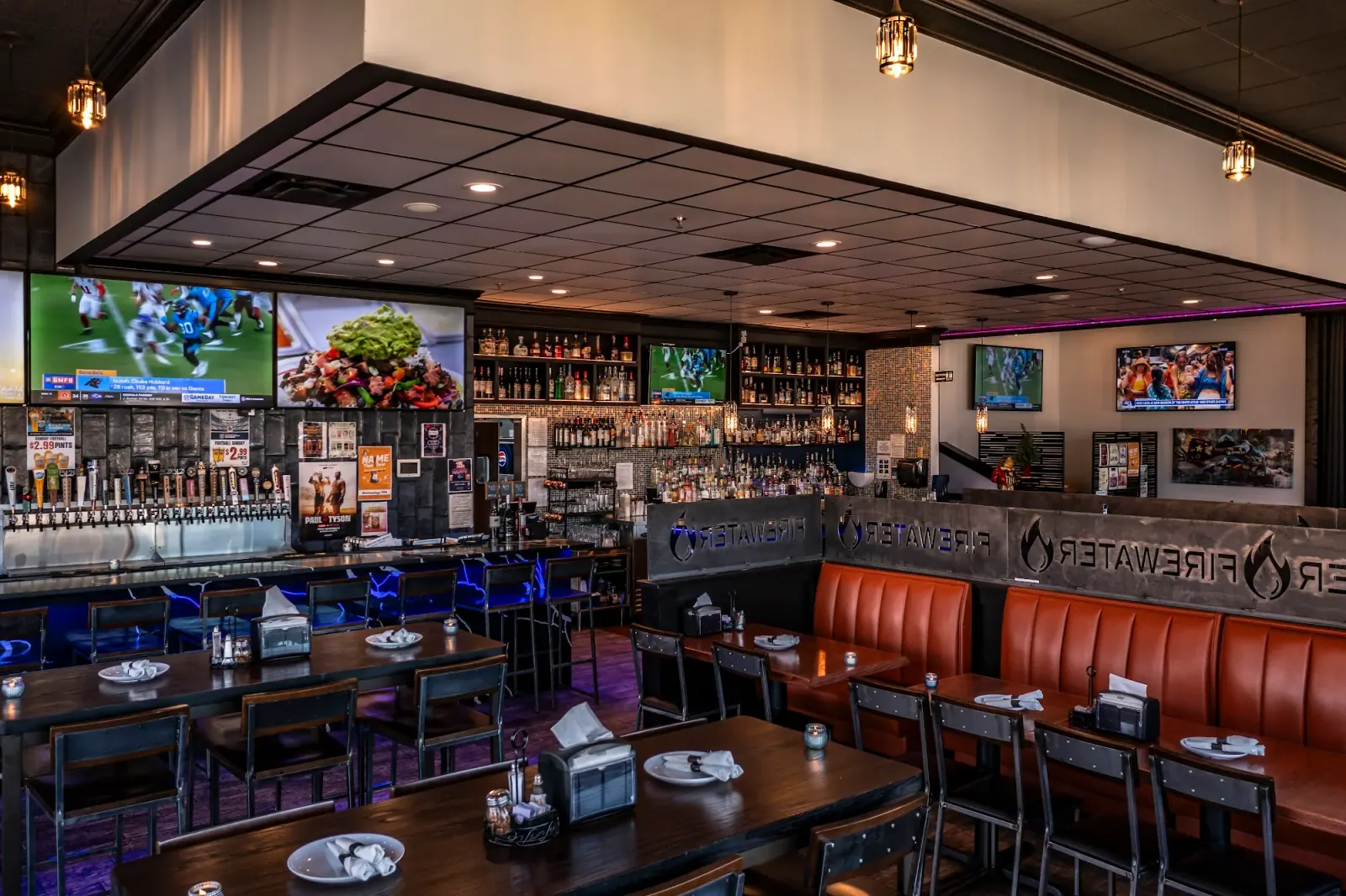 Main bar with branded Firewater bench seating and full liquor wall at Firewater Sports Bar Cafe