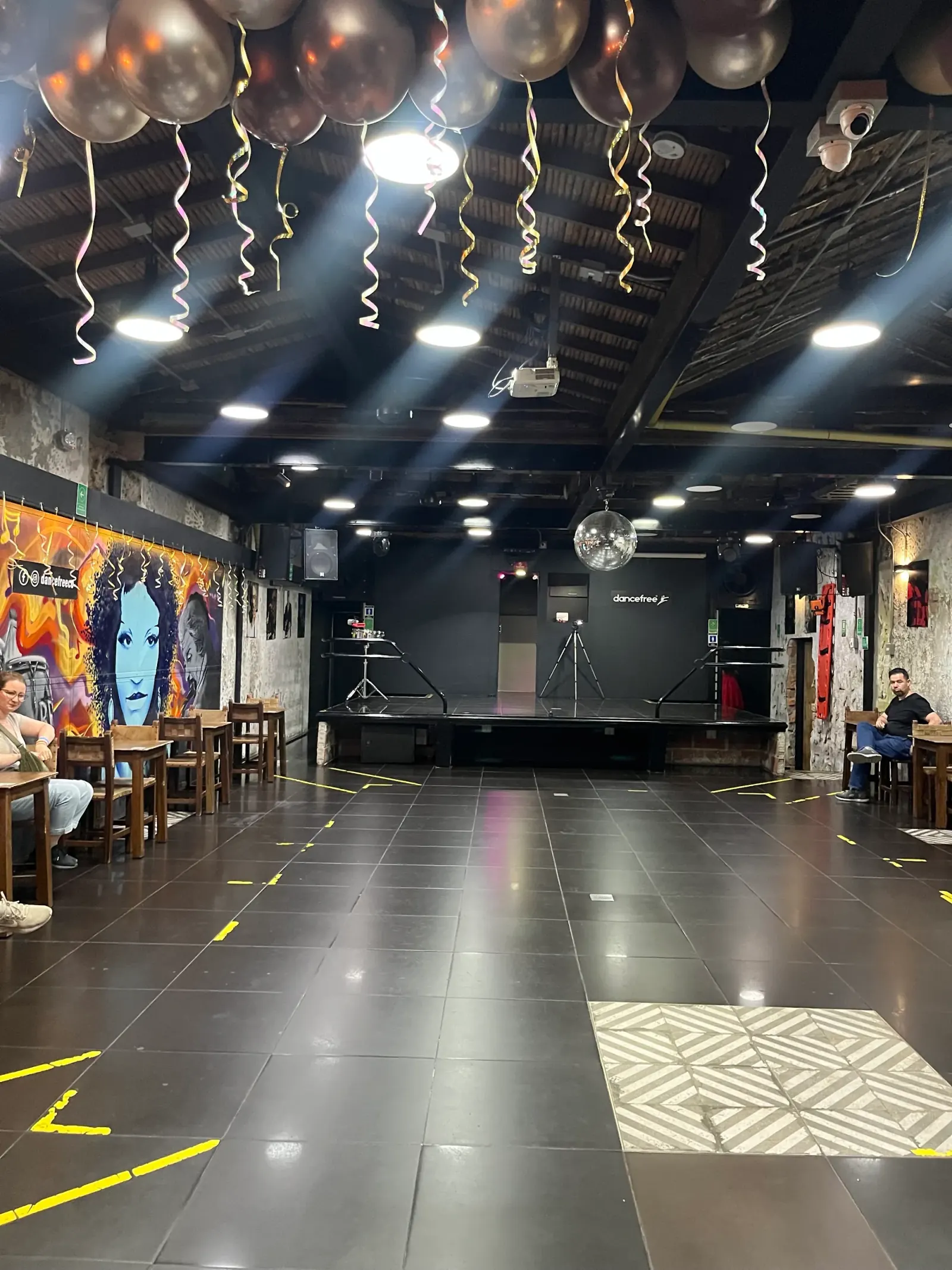Empty dance floor and stage with disco ball at Dancefree Medellin
