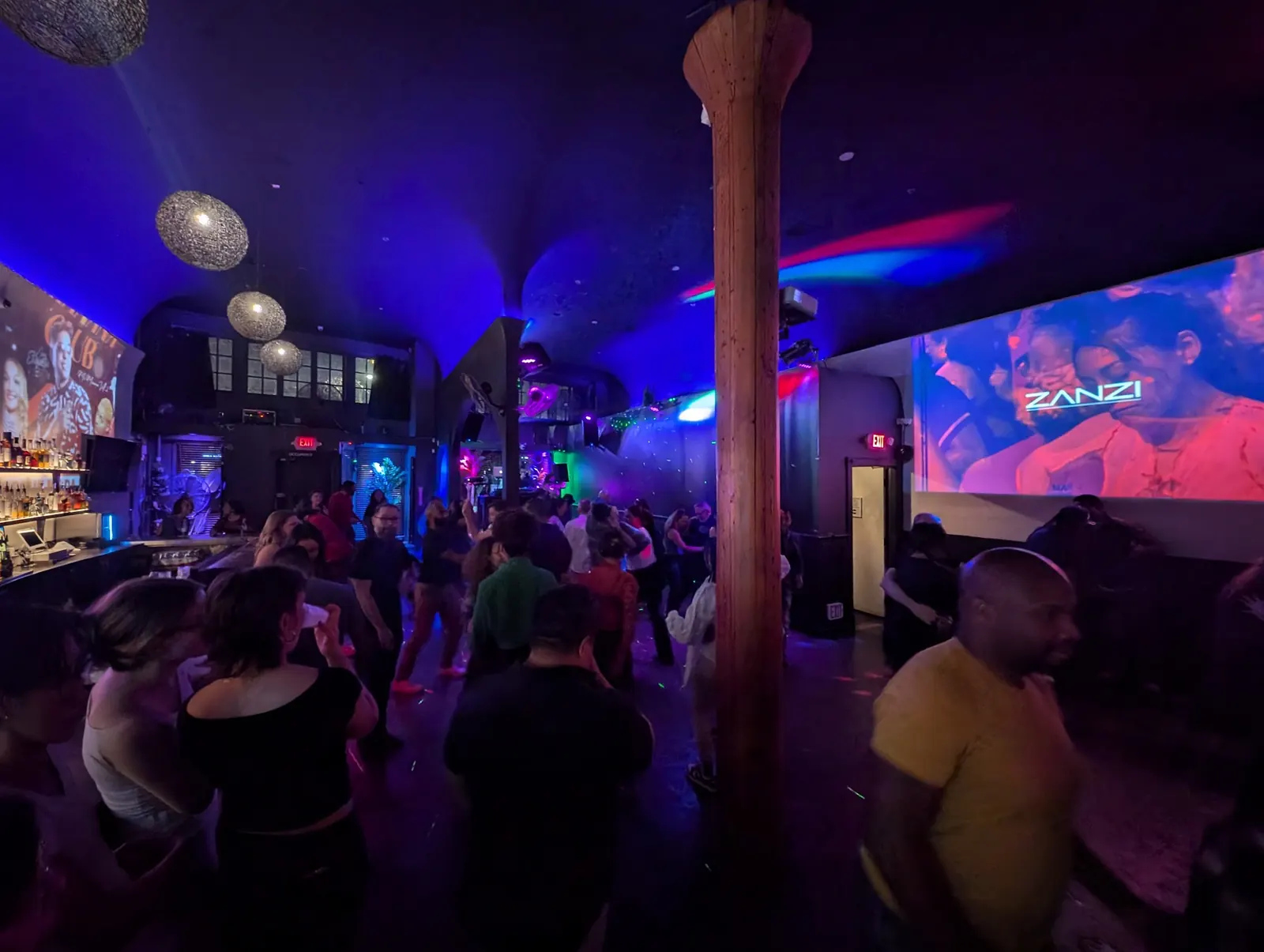 Crowd dancing under blue and purple lights at Zanzi in Oakland