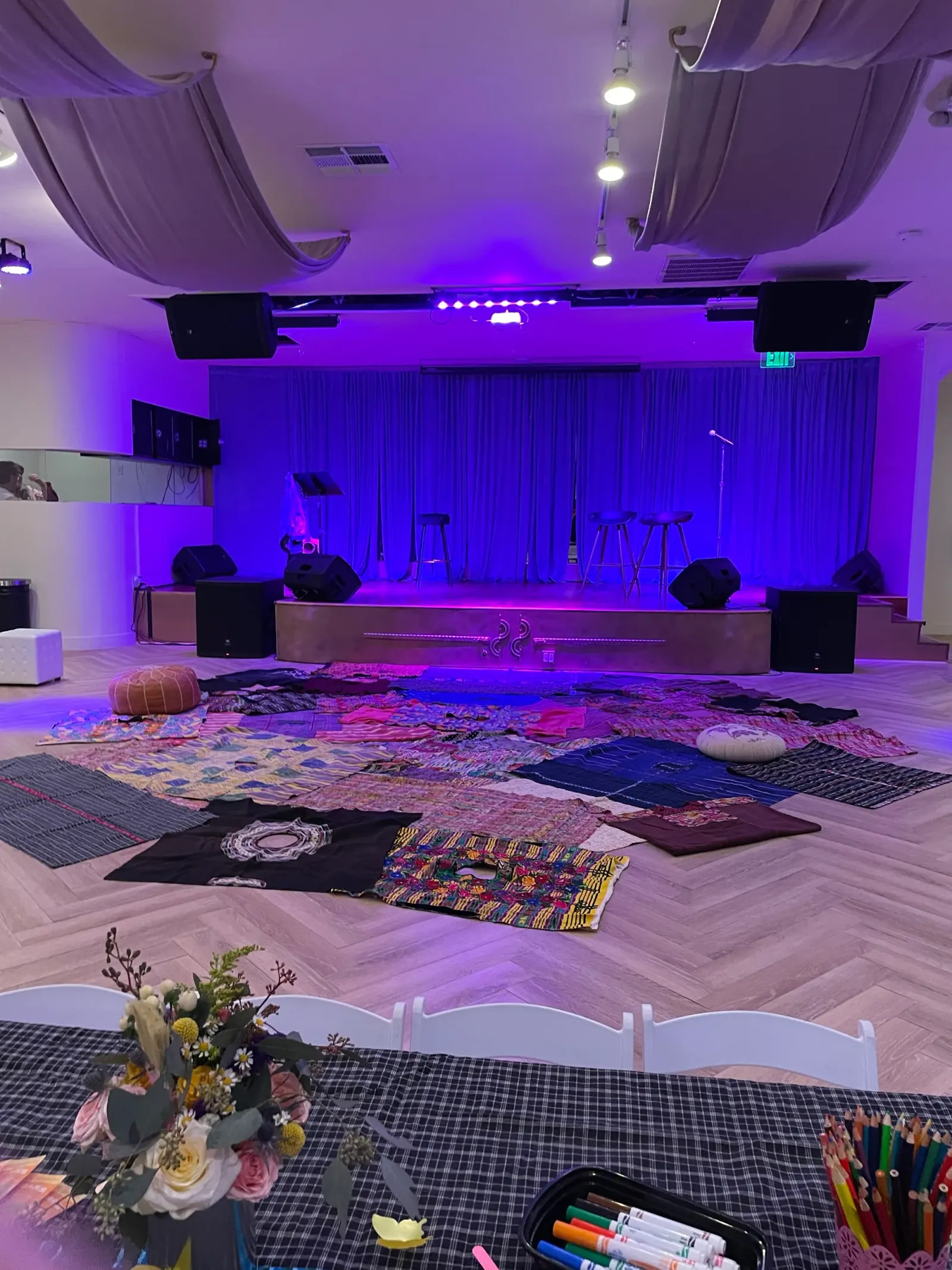 Dance hall interior at Little Light Venue with stage, blue curtain backdrop and dance floor with lighting rig