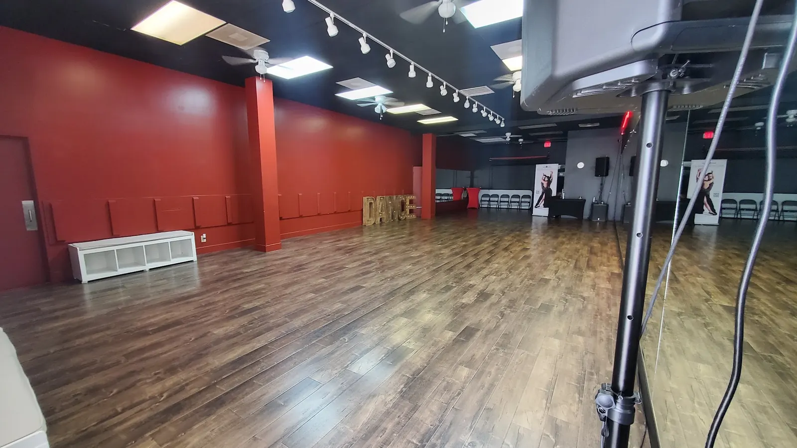Empty wooden dance floor and red walls in a second studio room at Dallas Can Dance
