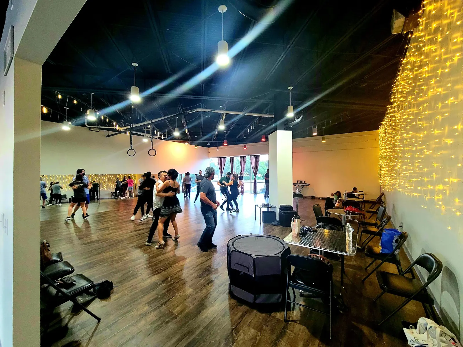 Couples social dancing under fairy lights in the large hall at Dallas Can Dance