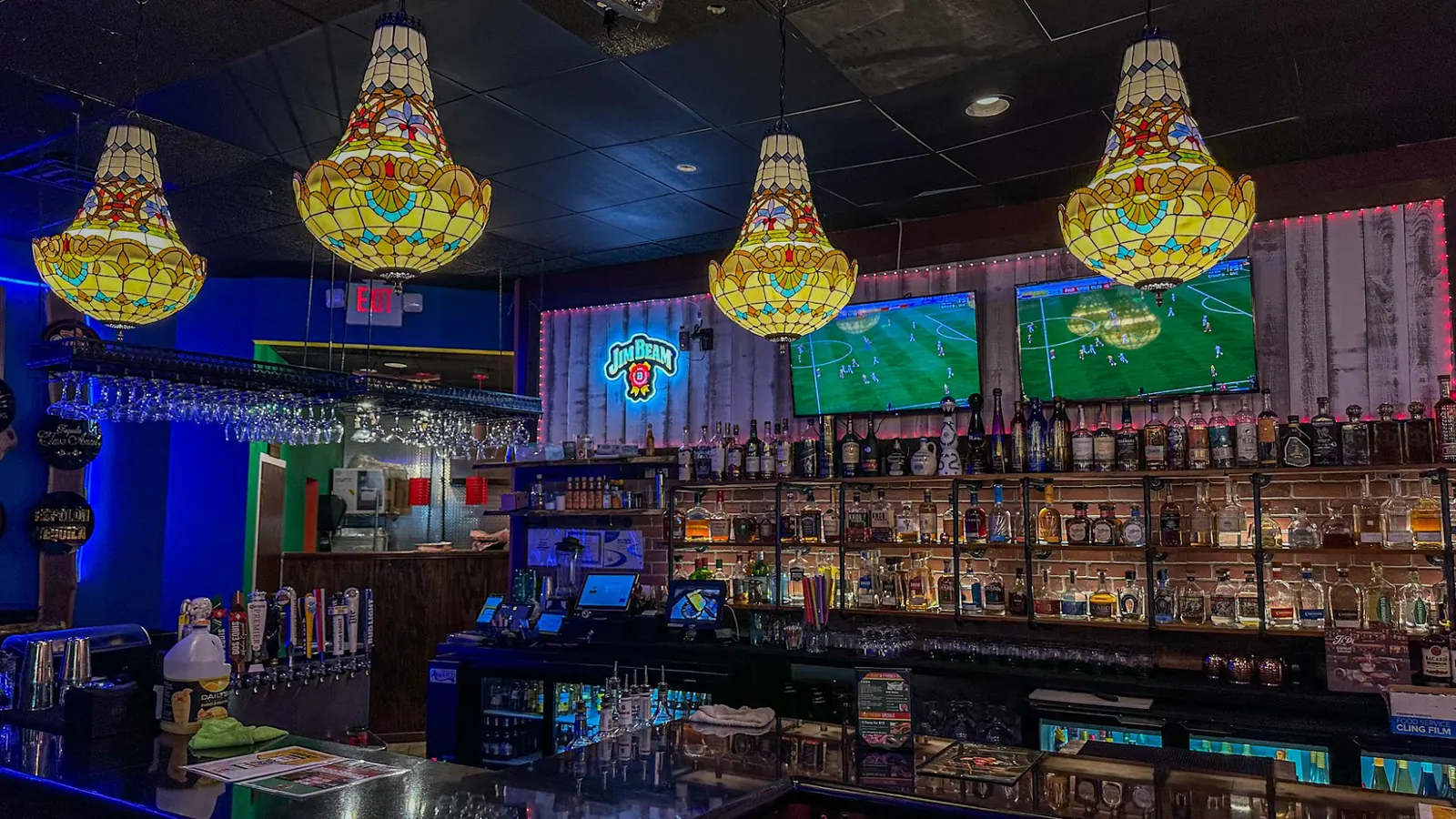Bar with tequila shelves and stained glass lamps inside Uncle Jalapeno, Herndon