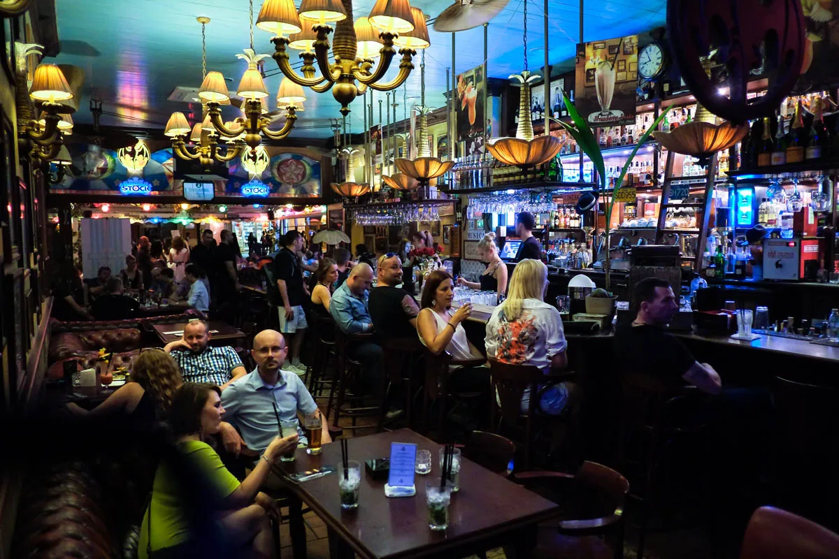 Busy night at Casa de la Musica Wroclaw with guests at the bar and ornate chandeliers