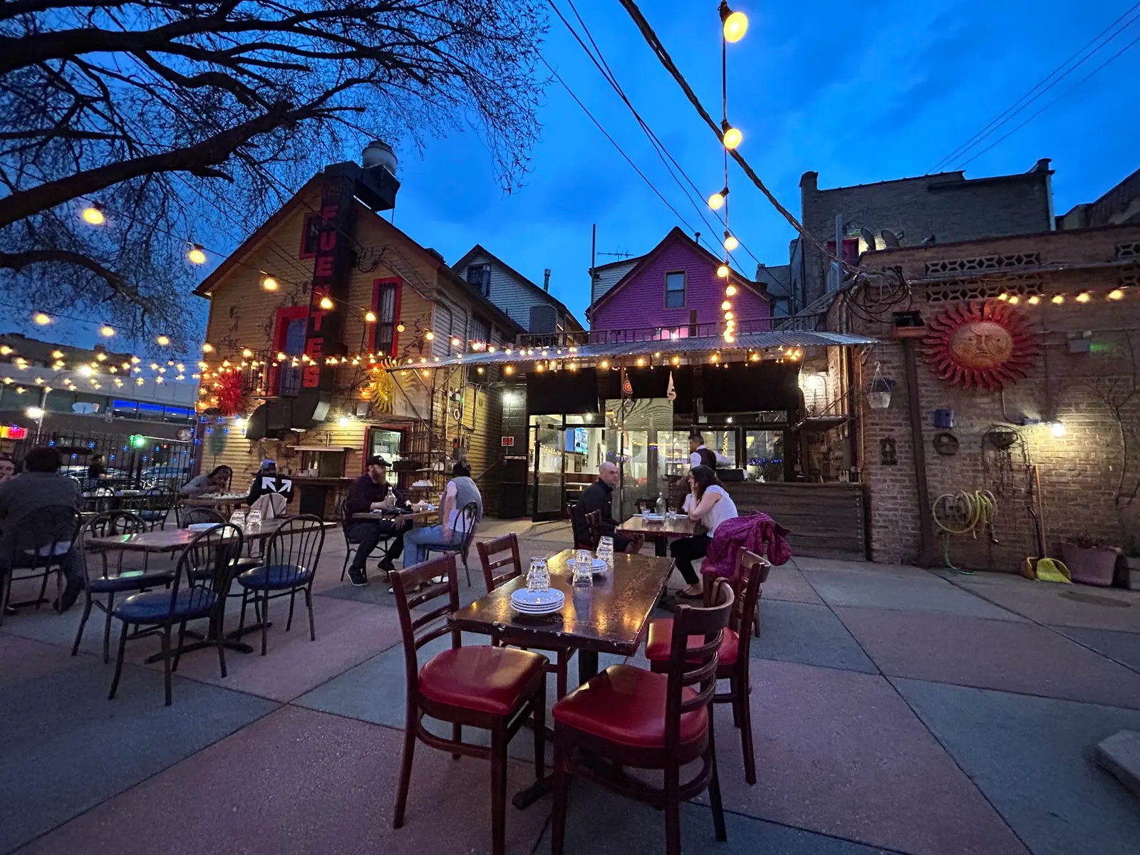 The lit Fuentes sign above the string lit patio at Las Fuentes in Chicago at dusk