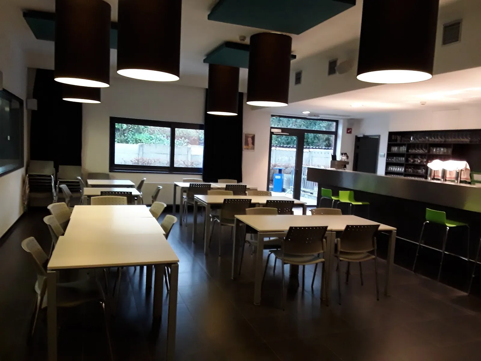 Cafe room with tables, chairs and the bar counter at GC De Corren in Brussels