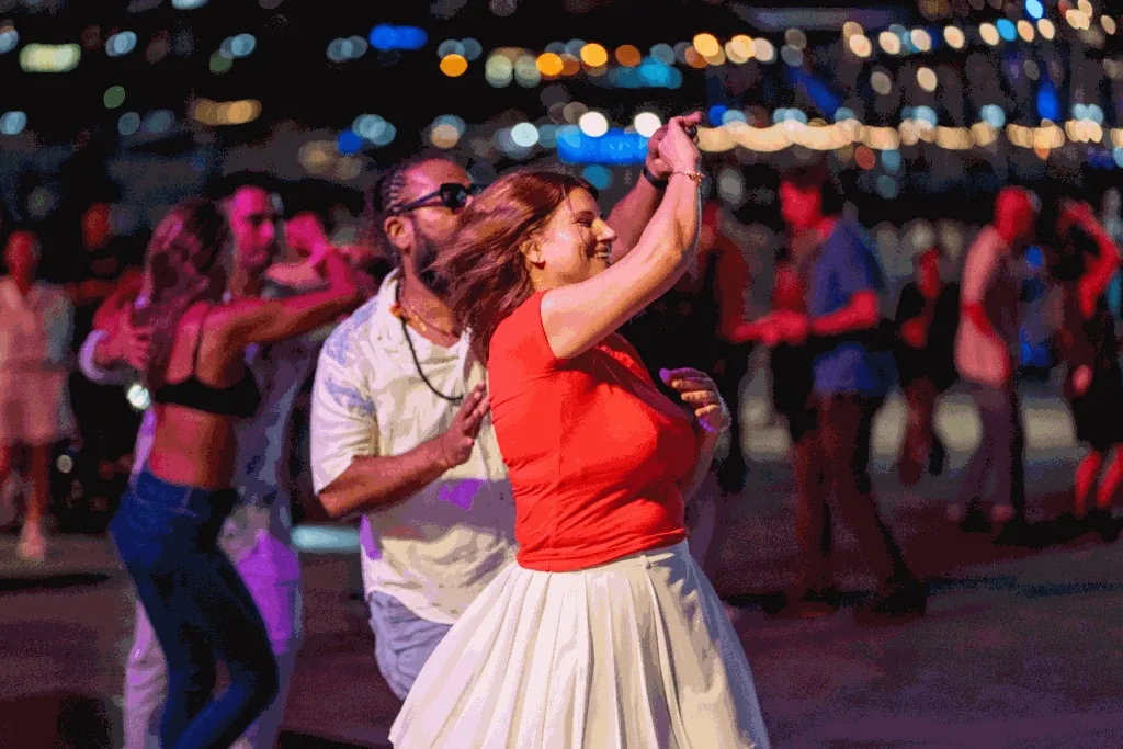 Couple dancing salsa with bokeh lights at Palm Grove Latin Nights, Darling Harbour Sydney
