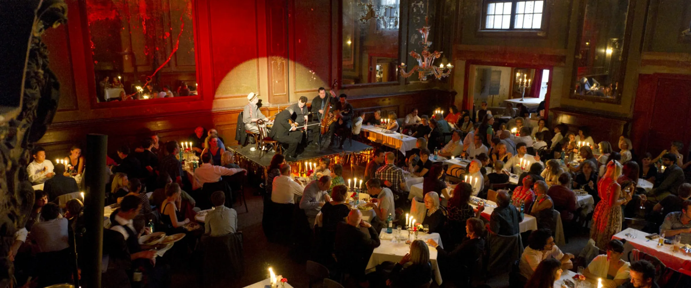 Candlelit evening at Clärchens Ballhaus Berlin with guests and live music in the historic ballroom