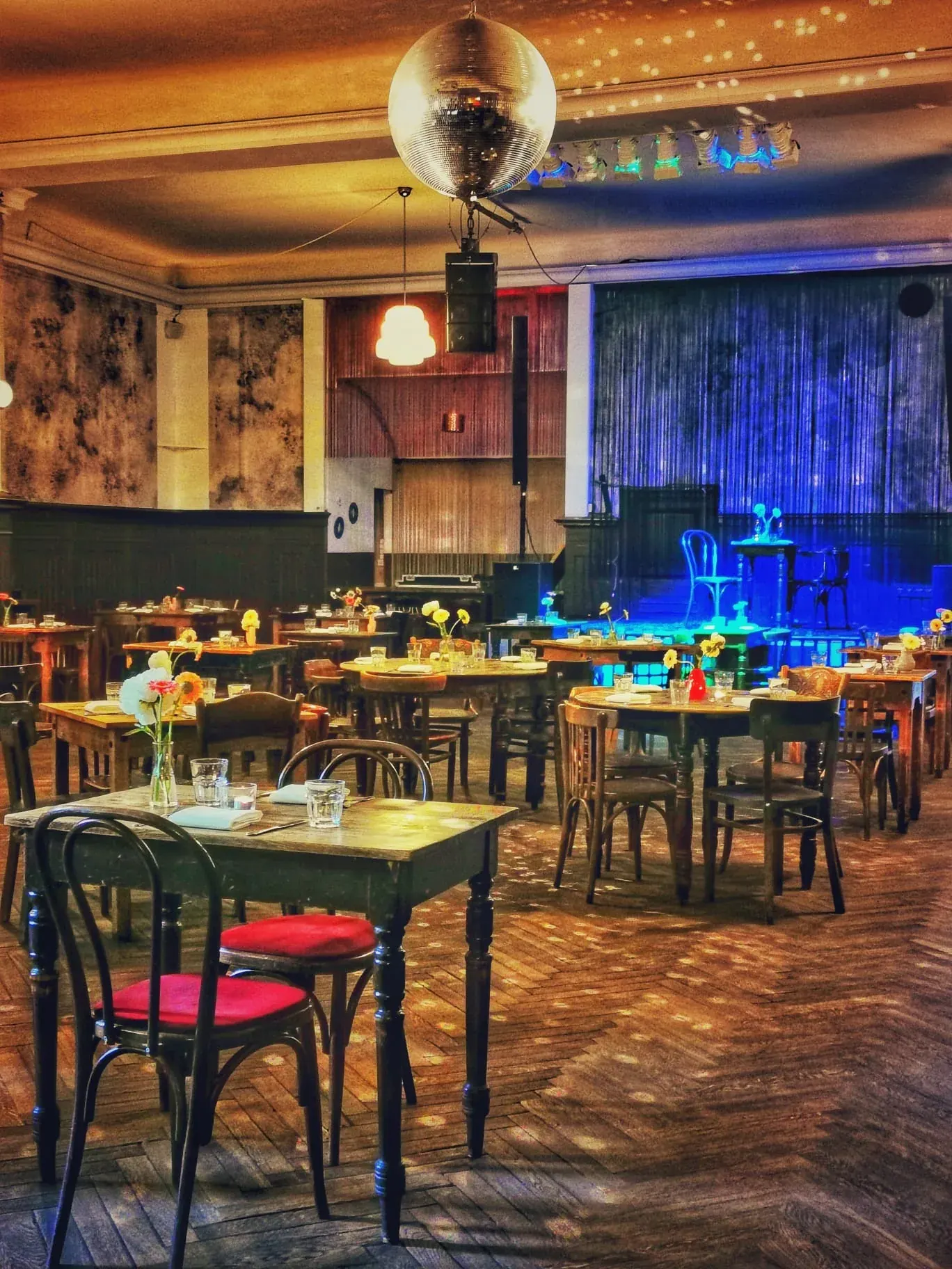 Ballroom interior with disco ball, stage and bistro tables at Clärchens Ballhaus, Berlin