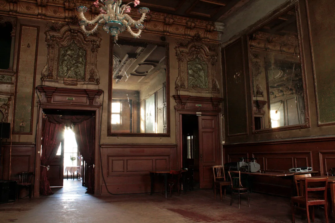 Historic Spiegelsaal (mirror hall) interior at Clärchens Ballhaus in Berlin with ornate chandeliers and mirrors