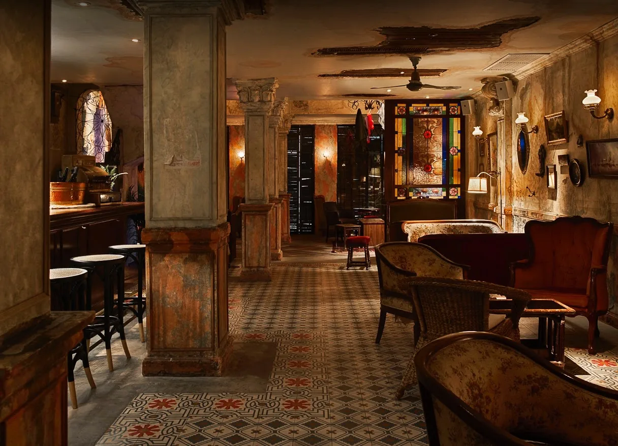 Vintage interior bar lounge with stained glass and antique furniture at Havana Social Bangkok