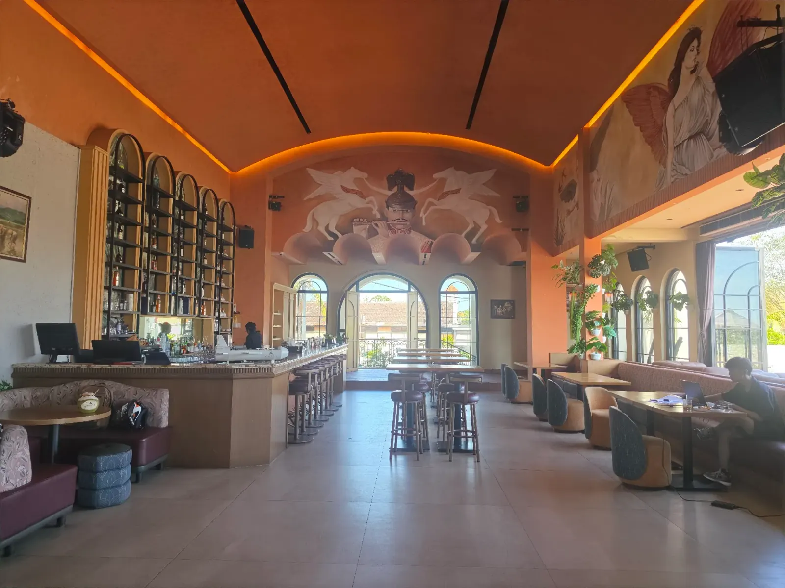 Bar with equestrian mural and vaulted ceiling at Amavi lounge in Canggu, Bali