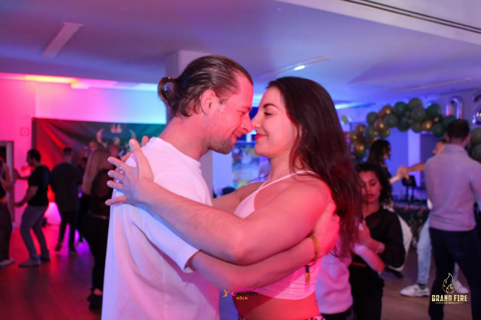 Couple dancing bachata among other dancers at Salsa Koeln in Cologne