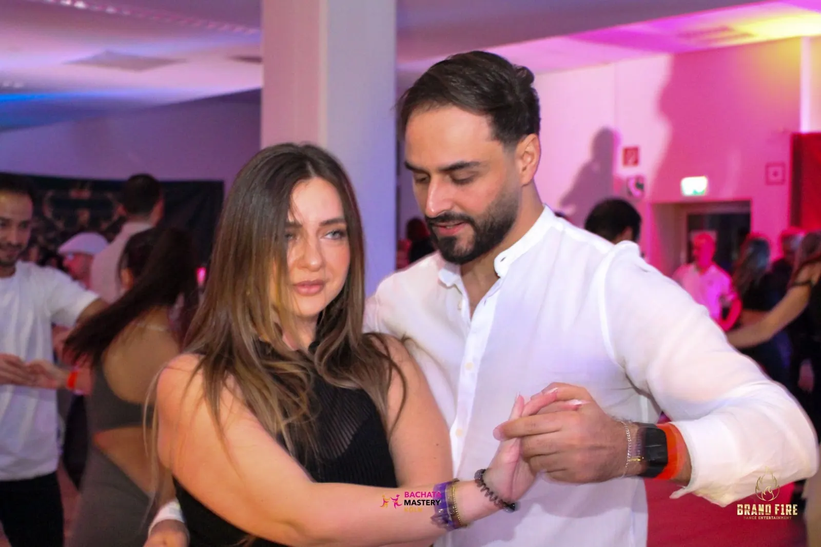 Couple in a partner hold on the pink lit dance floor at Salsa Koeln, Cologne