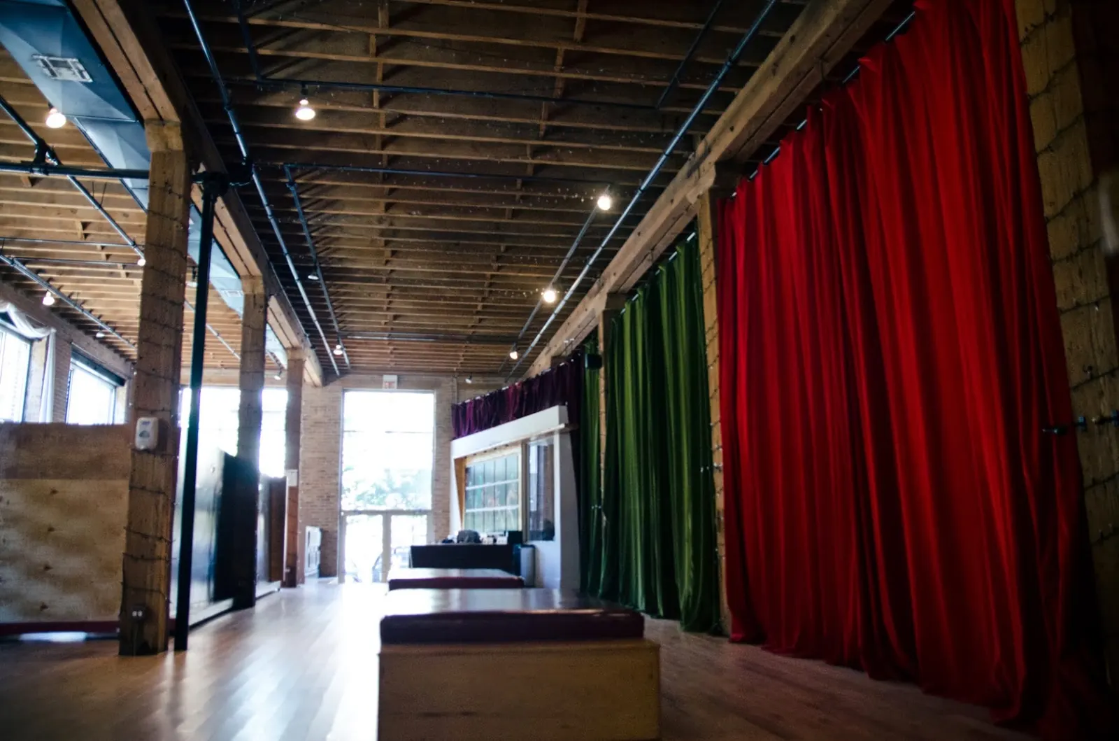 Wooden dance floor with red and green stage curtains at Latin Rhythms Academy, Chicago